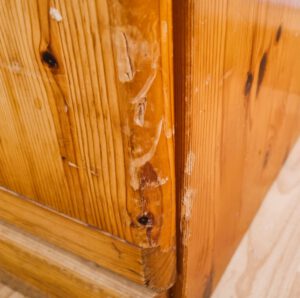 Nahaufnahme einer beschädigten Holzkommode mit tiefen Kratzern und Abnutzungsspuren – perfekte Basis für eine Upcycling-Möbelrestaurierung mit der Firma TREWIENS aus Erfurt