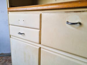 Vintage-Küchenschrank mit stark abgenutzten Fronten und alten Griffen – perfekter Kandidat für individuelles Upcycling in Erfurt oder professionelle Möbelrestaurierung durch die Werkstatt von Ulrike Niewerth